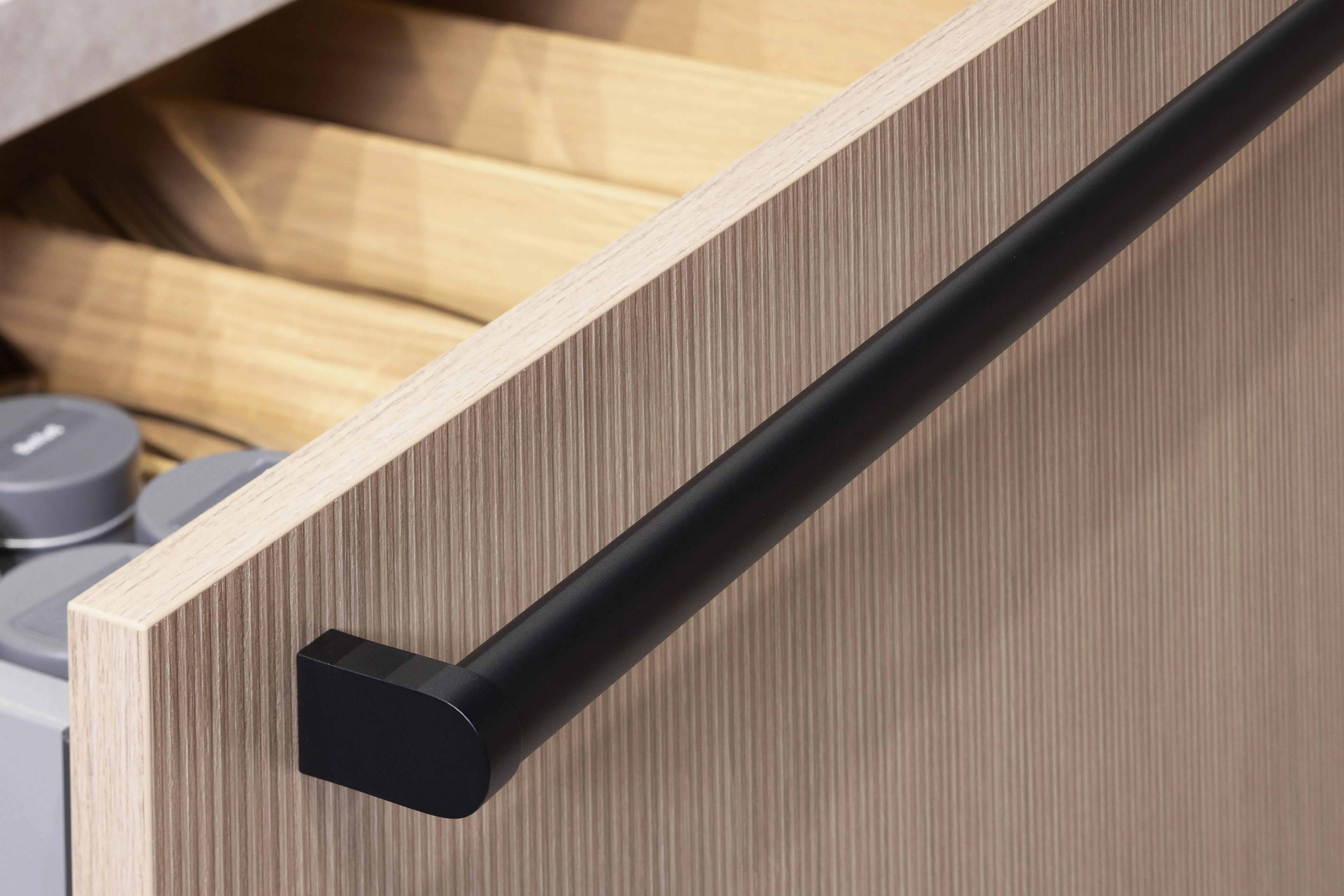 APL: Sandstein beige NB Front: Rillenoptik Eiche natur NB Front: MAC Tiefblau matt Korpus: Lavaschwarz Griff: Metallgriff Schwarz Geräte: Juno, Muldenlüfter BORA Armatur: Franke Spüle: Franke   Features: Kücheninsel mit Theke, Fliesen in Nischenrückwand, eingekoffertes Sideboard, Lichtstimmungen, offene Regale, Handtuchhalter Clip für Unterschranktüren, Kompaktbackofen, Planung ohne Sockel bodentief. 