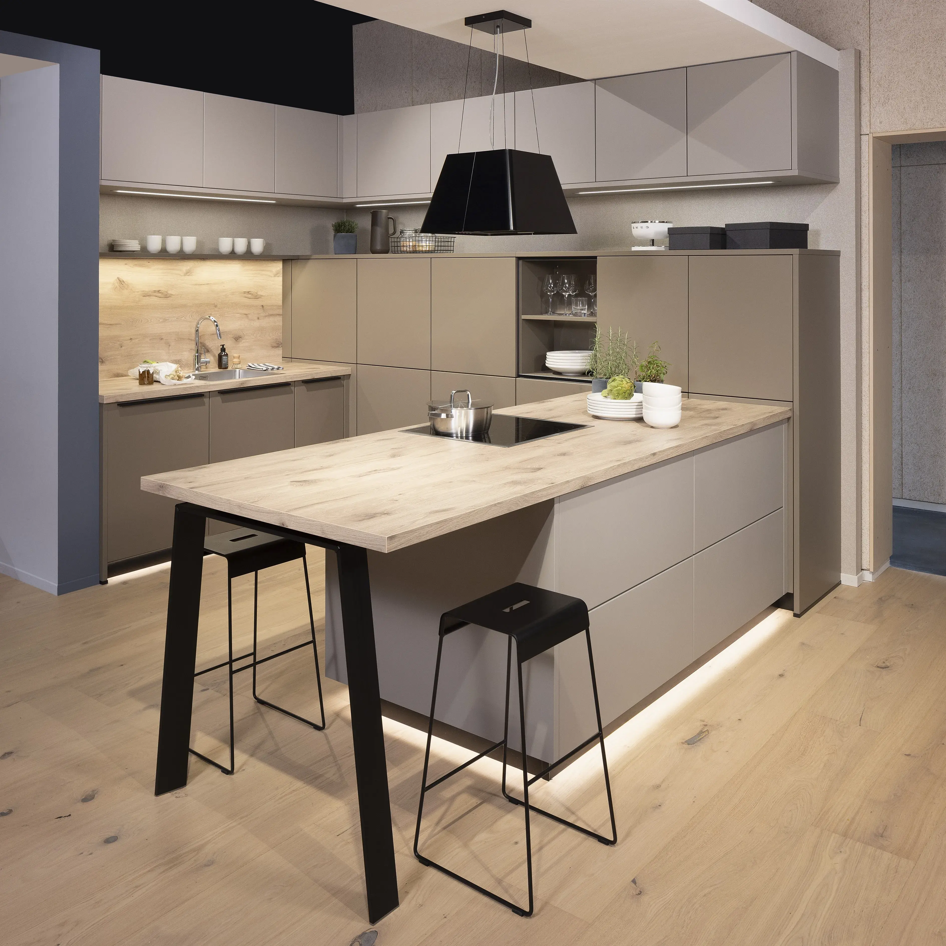 APL: Patagonia Eiche NB Front: Kaschmirbraun satin Front: Sepiabraun satin Korpus: Lavaschwarz Griff: Metall Schwarz Geräte: Bosch Armatur: Blanco Spüle: Blanco   Features: Farbkombination mit zwei Brauntönen kombiniert mit Eiche APL und Nischenrückwand (NB), Oberschrankplanung, Ablageraum auf Augenhöhe, Thekenlösung mit Tisch, Dunstabzugshaube (Airforce), Edelstahl Aufsatzspüle, Schiebeelemente.