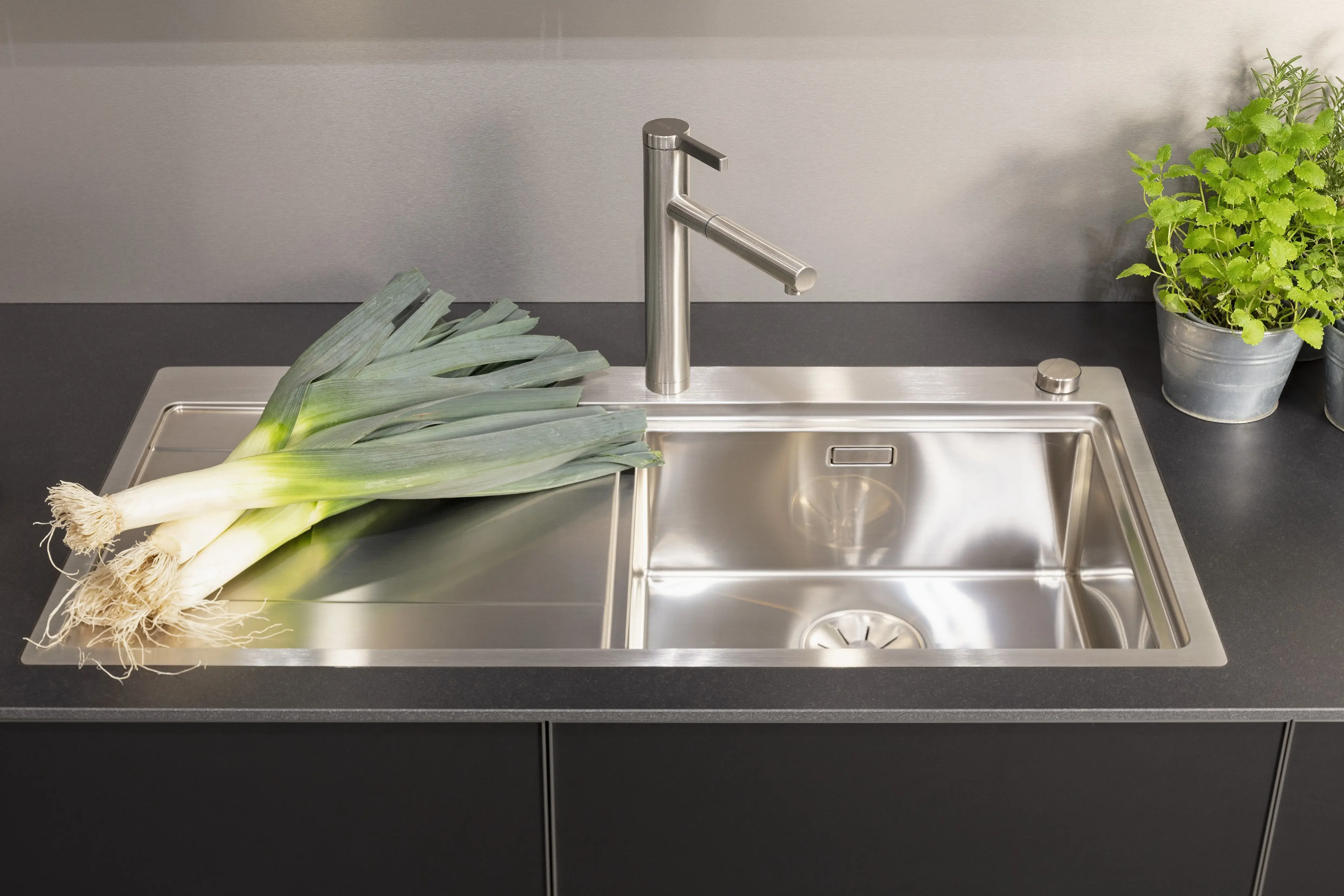 Front: Alu Tec RP Resopal Schwarz supermatt, Aluminiumkante APL: Schwarz Mikrostruktur  Geräte: Bora  Armatur und Spüle: Blanco  Features: stringentes Raster, Oberschränke quadratisch, Aluminiumkante, Regalsystem mit LED, Korpus Resopal Schwarz, Downlights, Schwarz/Edelstahl, Regale mit Edelstahlrückwand, Schubladen Holzfurnier. 